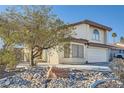 Two-story house with a large tree and rock landscaping in front at 8633 Portofino Ct, Las Vegas, NV 89117