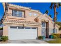 Two-story house with beige exterior, white garage door, and landscaped lawn at 8986 Lillyhammer Ct, Las Vegas, NV 89147