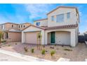 Two-story home with green front door, brick driveway, neutral color scheme, and desert landscaping at 9247 Lunar Phase St, Las Vegas, NV 89143