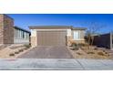 Modern single story house with a brown garage door and brick driveway at 9428 Noble Fir Ridge Ave, Las Vegas, NV 89143