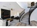 Living room with a modern fireplace, curved staircase, and stylish decor at 9541 Summersweet Ct, Las Vegas, NV 89123