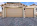 Three-car garage with stone exterior and neutral-colored doors at 3957 Little Creek Ave, Las Vegas, NV 89141