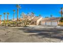 Exterior view of a home with a three car garage and palm trees at 7755 Coley Ave, Las Vegas, NV 89117