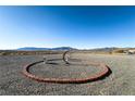 Landscaped yard with a unique circular design and desert mountain views at 2300 W Mielzynski Way, Pahrump, NV 89048