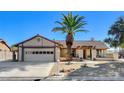 House exterior featuring a two-car garage and mature palm tree at 3331 Palmdesert Way, Las Vegas, NV 89120