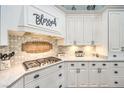 Bright kitchen with white cabinets, gas cooktop, and decorative backsplash at 5116 N Valadez St, Las Vegas, NV 89149