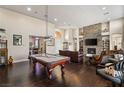 Elegant living room featuring a pool table and dark hardwood floors at 7670 Frittata Ave, Las Vegas, NV 89113