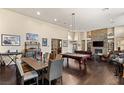 Spacious living room with a stone fireplace, pool table, and hardwood floors at 7670 Frittata Ave, Las Vegas, NV 89113