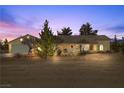 Well-lit single story house exterior at dusk at 1230 Bruce St, Pahrump, NV 89048