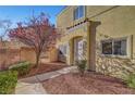 Townhome entrance with walkway, landscaping, and red tree at 3929 Pepper Thorn Ave # 101, North Las Vegas, NV 89081