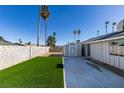 Artificial turf backyard with storage shed and paved patio area at 3994 Avonwood Ave, Las Vegas, NV 89121