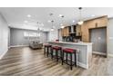 Open concept kitchen with island and view into living room at 4431 El Cebra Way, Las Vegas, NV 89121