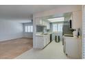Bright kitchen featuring white cabinets, stainless steel appliances, and tile flooring, open to the living area at 5340 Silvermist Ct # 103, Las Vegas, NV 89122