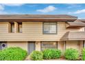 Tan townhome with gray door and landscaping at 6133 Meadowgrass Ln, Las Vegas, NV 89103