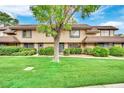 Tan two-story townhome with grassy yard at 6133 Meadowgrass Ln, Las Vegas, NV 89103