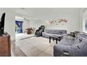 Living room with tiled floors, couches, and TV at 6133 Meadowgrass Ln, Las Vegas, NV 89103