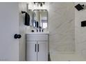 Updated bathroom with marble-look tile and black fixtures at 647 Greenbriar Townhouse Way, Las Vegas, NV 89121