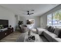 Virtually staged living room with light grey couch and armchair at 647 Greenbriar Townhouse Way, Las Vegas, NV 89121