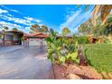 Front view of a home with a two-car garage and desert landscaping at 6640 Palmyra Ave, Las Vegas, NV 89146