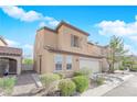 Beige two-story house with a two-car garage and landscaping at 7490 Thistle Poppy St, Las Vegas, NV 89139