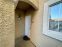 Inviting front door entrance with stucco walls, a cozy porch light, and a tidy welcome mat at 833 Aspen Peak Loop # 1014, Henderson, NV 89011