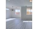 Dining area with grey wood-look floors and a modern chandelier at 9279 Cabin Cove Ave, Las Vegas, NV 89148