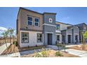 Modern two-story townhome with gray and beige exterior, landscaping, and a bench at 9315 Jade Mesa St # Lot 62, Las Vegas, NV 89139