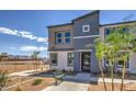 Contemporary two-story townhome with gray and beige exterior, landscaping, and a bench at 9315 Jade Mesa St # Lot 62, Las Vegas, NV 89139