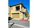 Tan two-story townhome with attached garage and additional parking at 965 Nevada State Dr # 1202, Henderson, NV 89002