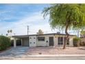 Mid-century modern home with carport and mature tree at 1208 Clairemont St, Las Vegas, NV 89110