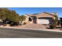 Tan house with a three-car garage and mature trees at 1736 Williamsport St, Henderson, NV 89052