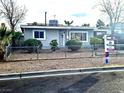 Gray single story house with chain link fence and small front yard at 1920 Walnut Ave, Las Vegas, NV 89101