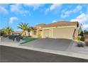 House with tan exterior, three-car garage, and American flag at 2080 Twin Falls Dr, Henderson, NV 89044