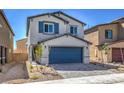 Two-story house with gray siding, blue garage door, and landscaped front yard at 2642 Snapdragon Falls Ave # 93, North Las Vegas, NV 89081