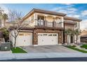 House exterior showcasing stone and stucco, three-car garage, and landscaping at 2768 Liberation Dr, Henderson, NV 89044