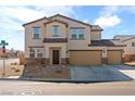 Two-story house with tan siding, stone accents, and a three-car garage at 3981 E Teller Dr, Pahrump, NV 89061