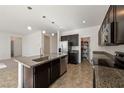 Spacious kitchen with dark cabinets, granite countertops, and stainless steel appliances at 3981 E Teller Dr, Pahrump, NV 89061