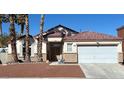 Inviting single-story home boasts well-kept landscaping, a two-car garage, and a classic, neutral-toned stucco exterior at 414 Maritocca Ave, North Las Vegas, NV 89031