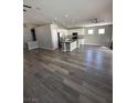 Spacious open-concept living area featuring new gray, wood-look vinyl plank flooring and updated lighting at 414 Maritocca Ave, North Las Vegas, NV 89031