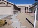 Tan house with a two-car garage and walkway leading to the entrance at 4522 Checker Way, North Las Vegas, NV 89031