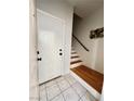 View of front door and stairs in the home's entryway with tile floors at 6449 Stone Dry Ave # 101, Henderson, NV 89011