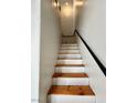 View of staircase with wood treads, white risers, and black metal railing, ascending to the upper level at 6449 Stone Dry Ave # 101, Henderson, NV 89011