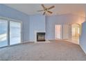 Spacious living room with light blue walls, a fireplace and carpet flooring at 6617 Old Newbury Ave, Las Vegas, NV 89108