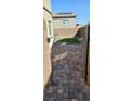 Cozy backyard featuring brick pavers and a small patch of synthetic grass at 7050 Fossil Rim St, Las Vegas, NV 89084