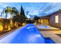 Stunning nighttime view of a large pool and spa at 7307 Iron Oak Ave, Las Vegas, NV 89113