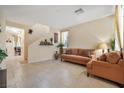 Living room with tile floors, brown couch and access to dining area at 8157 Amy Springs St, Las Vegas, NV 89113