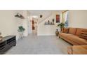 Living room with tile floors, brown couch, and view of staircase at 8157 Amy Springs St, Las Vegas, NV 89113