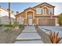 Two story house with a beautiful front yard and attached garage at 9131 Sangria Ln, Las Vegas, NV 89147