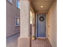 Gray front door with wreath, stone walkway, and a yellow welcome mat at 1112 Via Monticano, Henderson, NV 89052