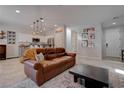 Living room with brown leather sofa, coffee table, and kitchen island view at 1112 Via Monticano, Henderson, NV 89052